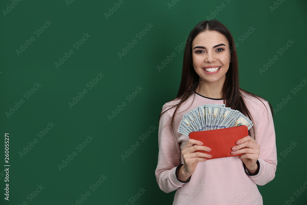 Young woman with money in wallet on color background. Space for text Young woman with money in wallet on color background. Space for text