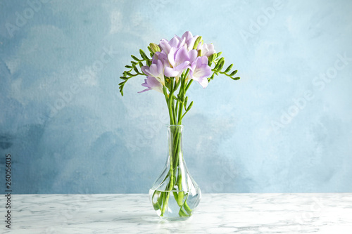 Bouquet of fresh freesia flowers in vase on table