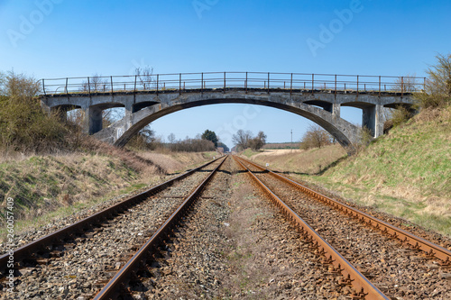 Old viaduct over the railway tracks. Concrete bridge over the railroad.