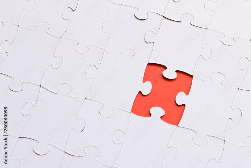 White jigsaw puzzles on red background. The concept of development of thinking. The concept of teamwork. White jigsaw puzzles on red background. The concept of development of thinking. The concept of teamwork.