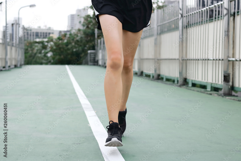 Cropped image of young runner running on street. Fitness and exercise concept.