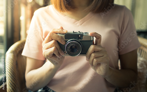 Female hold retro film camera in hand.