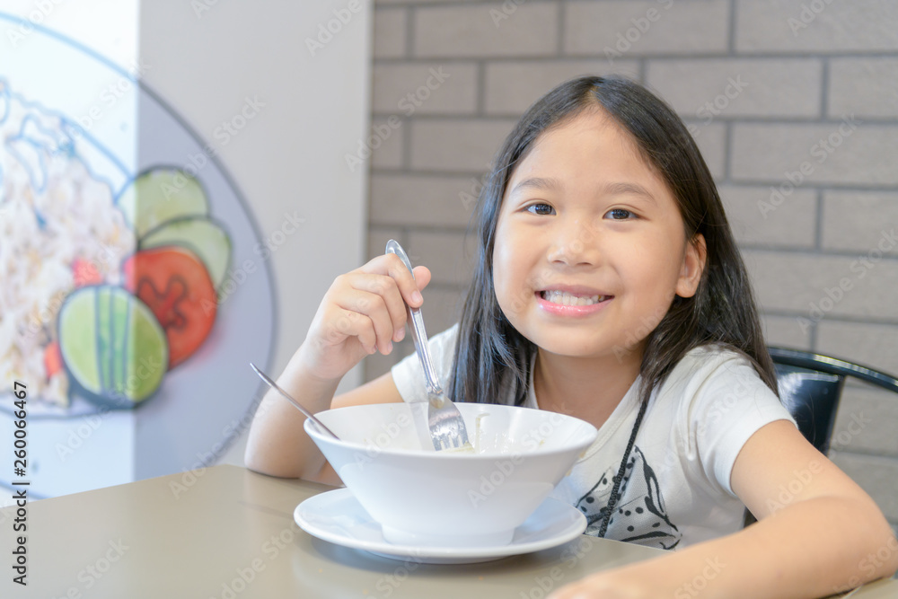 Cute girl eating noodle in food court