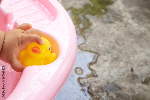 The little baby's hand caught the yellow duck while bathing.