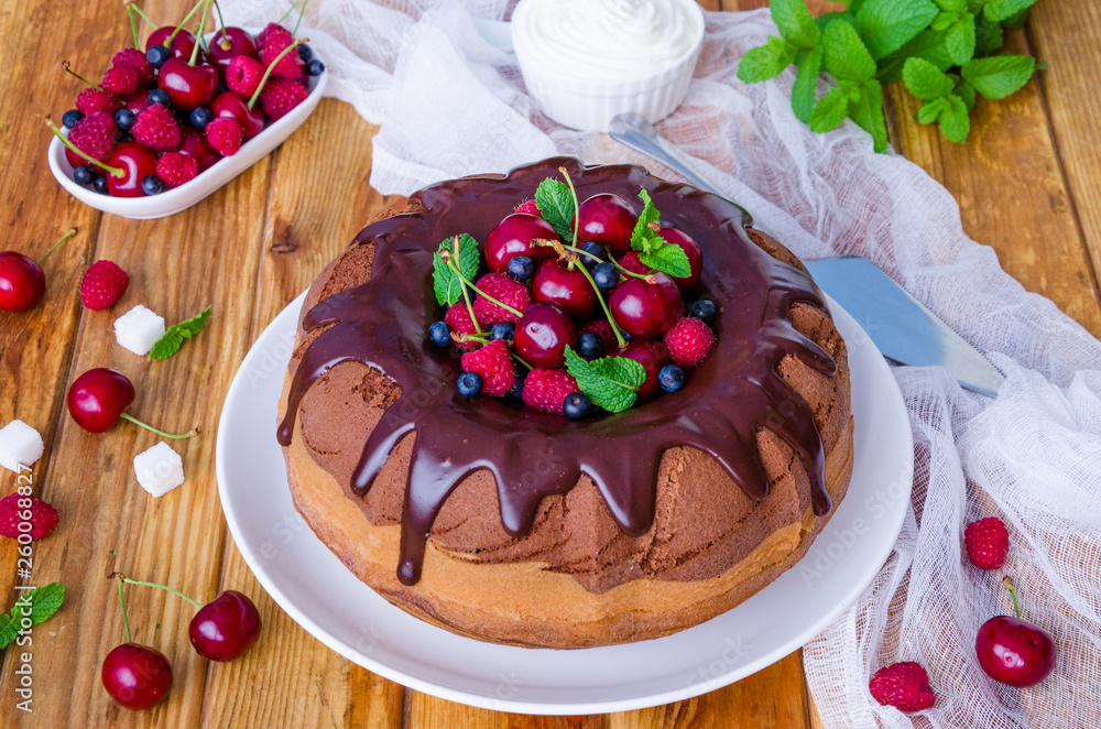 Marble cream cake with chocolate glaze, fresh berries, whipped cream and mint. Marble cream cake with chocolate glaze, fresh berries, whipped cream and mint.
