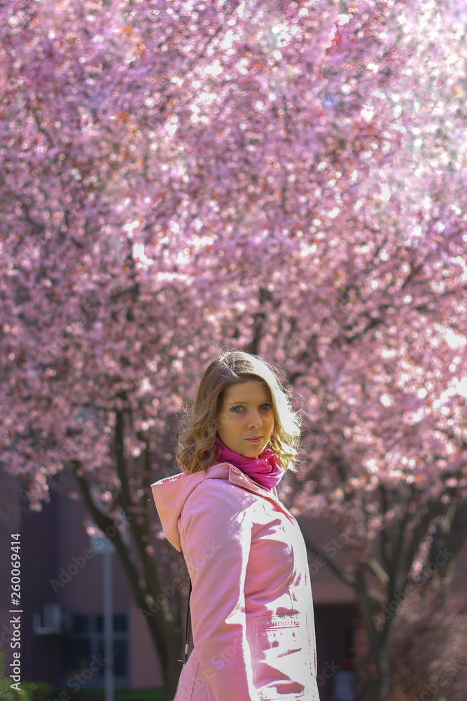Female posing, spring background with pink flowers Female posing, spring background with pink flowers