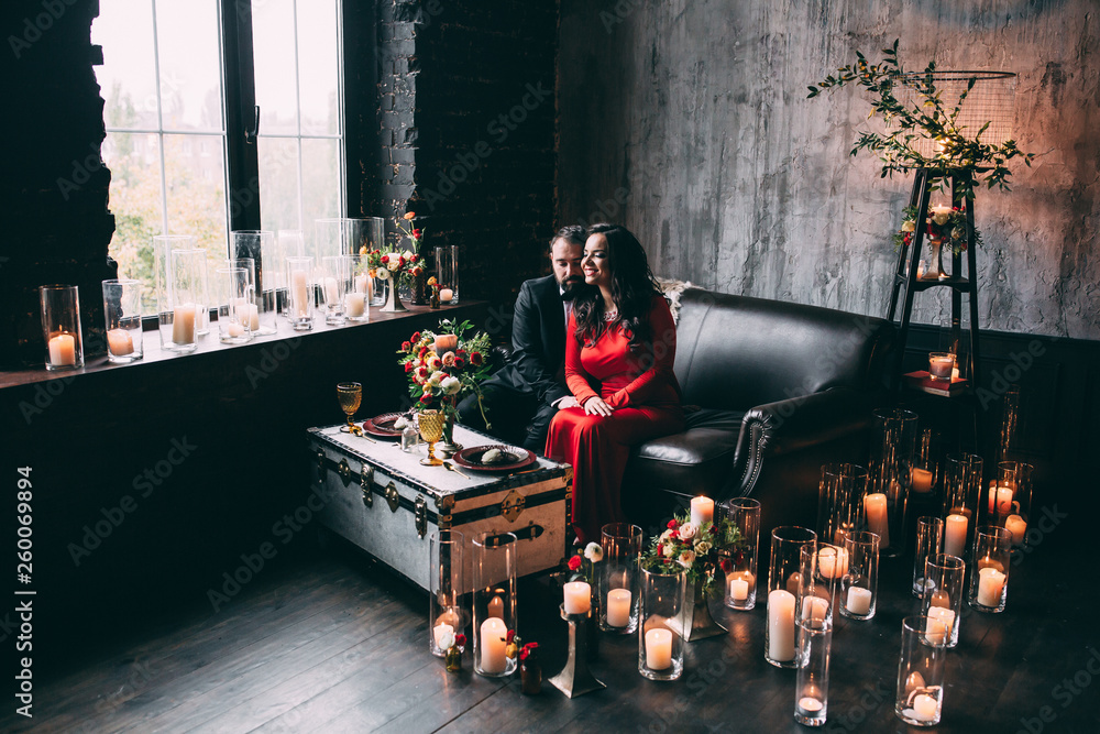 Photo session of the newlyweds in the studio. Red dress and black suit.