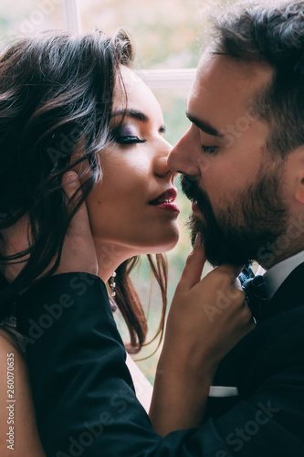 Portrait of the bride and groom. A passionate kiss.