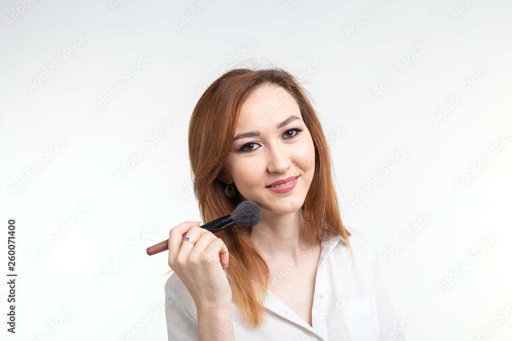 Attractive visagist or korean make-up artist holding a makeup brushes on white background Attractive visagist or korean make-up artist holding a makeup brushes on white background