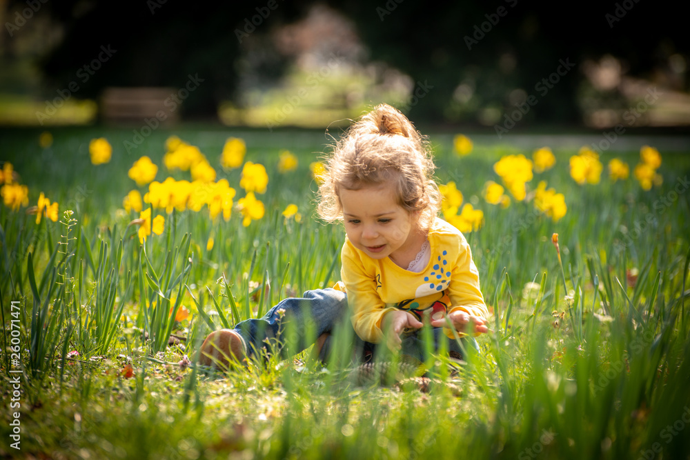 Girl playing on a sunny day in green field with yellow flowers Girl playing on a sunny day in green field with yellow flowers