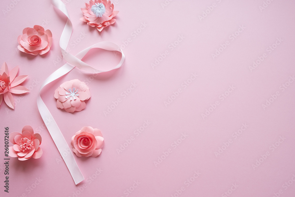 frame with pink paper flowers and pink ribbon on pink background. frame with pink paper flowers and pink ribbon on pink background.