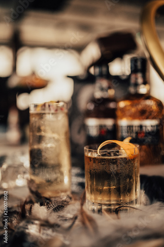 A close up shot of whisky cocktails with ice cubes and dry ice. Concept of fine alcohol, beverage and mixed cocktails. Luxurious lifestyle. Selective focus on the cocktails.