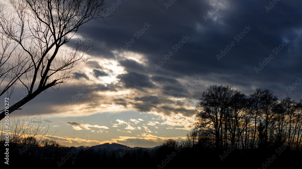 Fototapeta premium colorful sunset with hills, clouds and trees