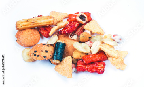 Mix of Asian snack on white background. Including Nori Maki Arare rice crackers in seaweed, glaze peanuts and fried crackers. Close up.