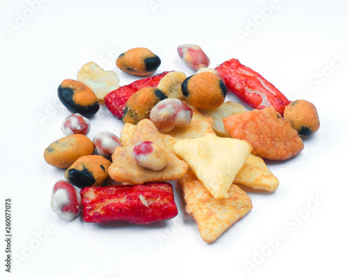 Mix of Asian snack on white background. Including Nori Maki Arare rice crackers in seaweed, glaze peanuts and fried crackers. Close up.