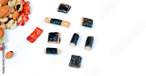 Mix of Asian snack on white background. Japanese nori maki arare rice crackers in seaweed, glaze peanuts. Close up with Space for text.