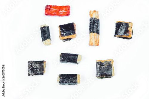 Mix of Asian snack on white background. Including Nori Maki Arare rice crackers in seaweed, glaze peanuts and fried crackers. Close up.
