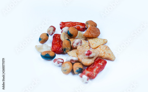 Mix of Asian snack on white background. Including Nori Maki Arare rice crackers in seaweed, glaze peanuts and fried crackers. Close up.