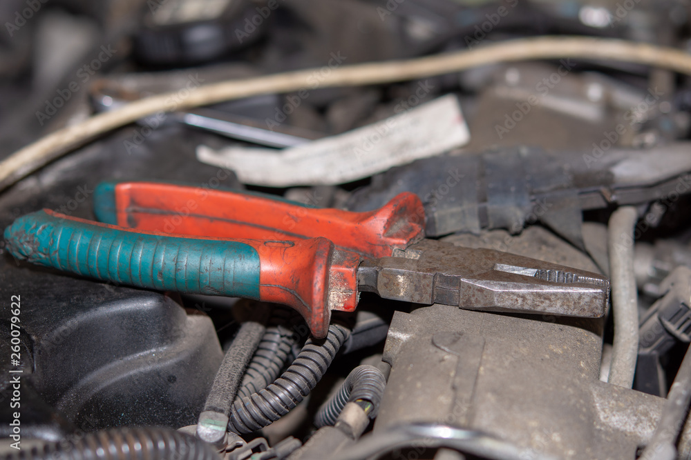 Combined pliers on the old diesel engine. Car mechanic repairs concept with old car engine. Combined pliers on the old diesel engine. Car mechanic repairs concept with old car engine.