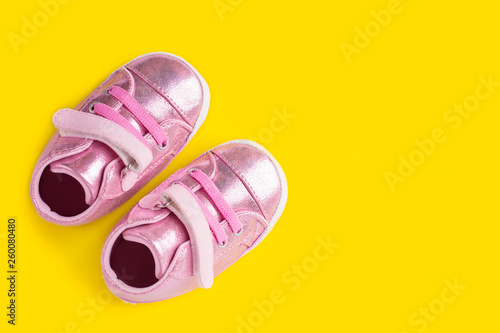 Wallpaper Mural A pair of beautiful sneakers for the baby. Fashionable sneakers for kids on yellow background. Torontodigital.ca