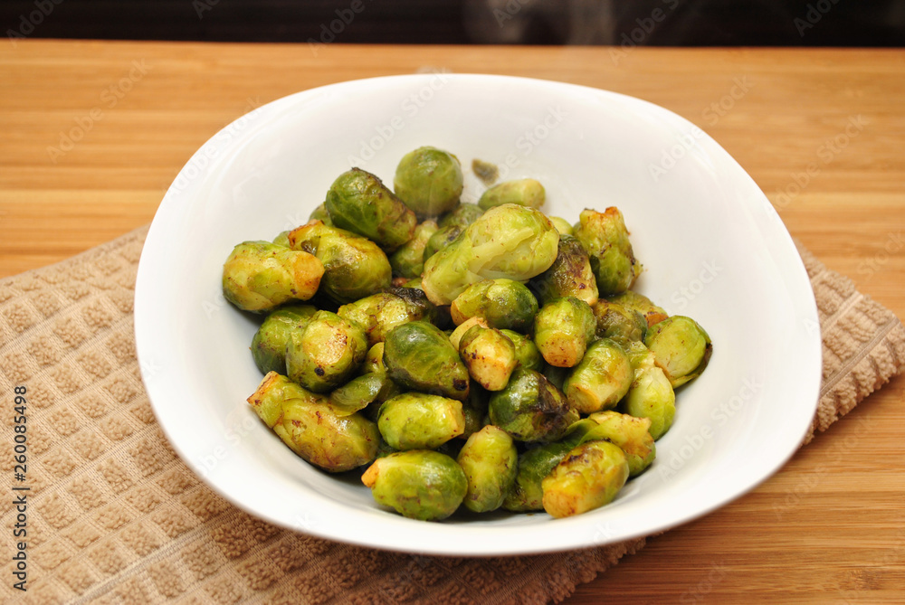 Steaming Hot Roasted Brussel Sprouts in a White Bowl Steaming Hot Roasted Brussel Sprouts in a White Bowl