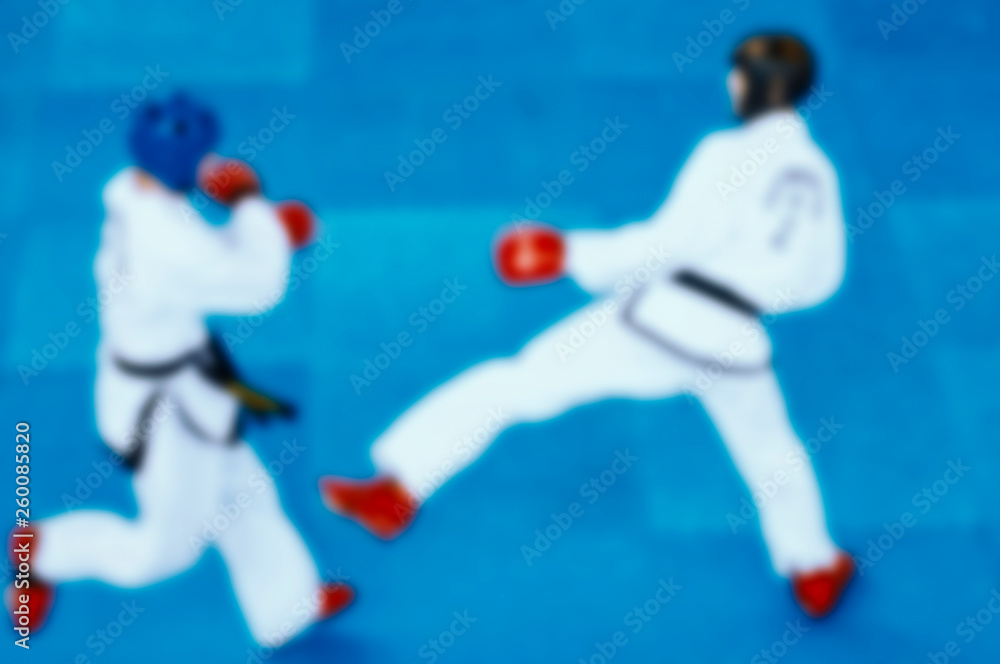 Fototapeta premium taekwondo blurred background. two men in white clothes on a blue background