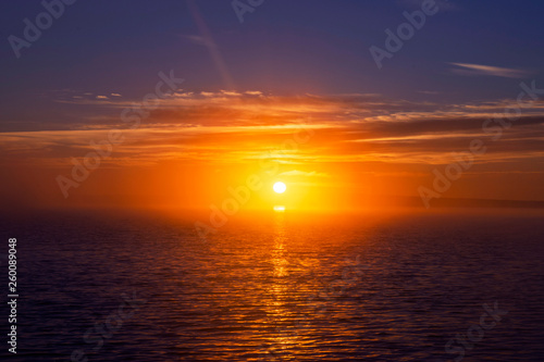Sunset sky background. Dramatic gold sunset sky with evening sky clouds over the sea. Stunning sky clouds in the sunrise. Sky landscape. Panoramic sky view. © Aleksei