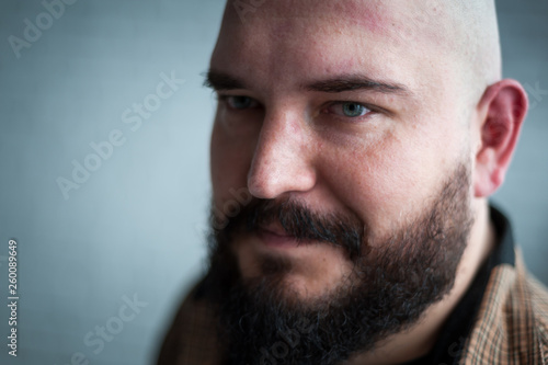 Portrait of a bald man in a shirt with a beard