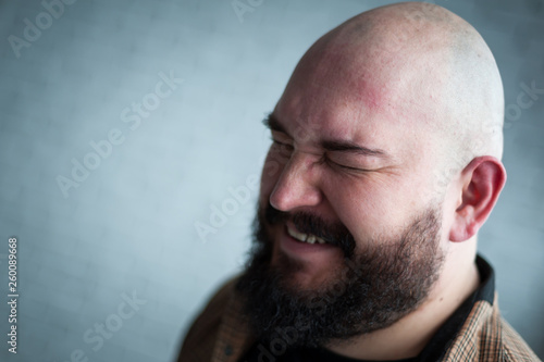 Portrait of a bald man in a shirt with a beard