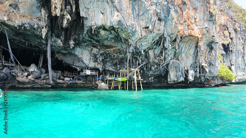 Sheer cliffs, blue water and a Viking cave. Phi Phi Islands, Thailand. See the stalactites, and built of bamboo. The turquoise colour of the water. Unusual landscape. The stones of the deserted island