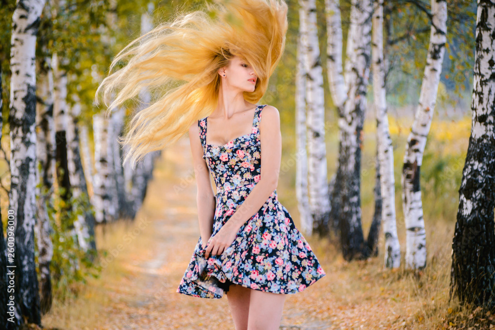 An attractive girl with fluttering hair and a short dress walks in the Park. An attractive girl with fluttering hair and a short dress walks in the Park.