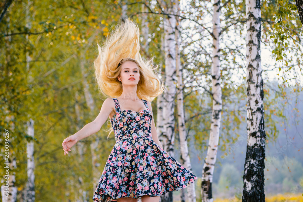 An attractive girl with fluttering hair and a short dress walks in the Park. An attractive girl with fluttering hair and a short dress walks in the Park.