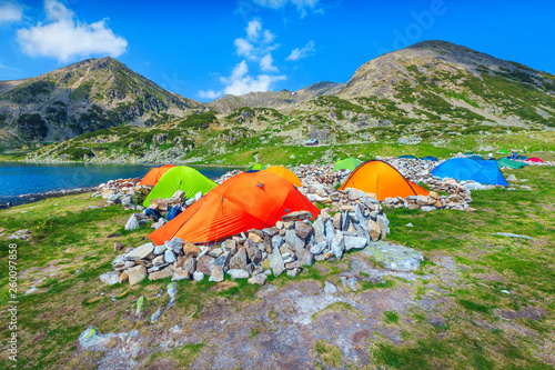 Colorful camping tents near alpine lake in the mountains, Romania