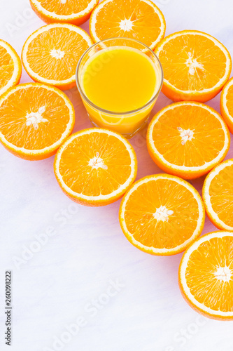 Halved oranges fruit and glass of juice. Citrus for making juice. A lot of sliced oranges on a white background. Background of oranges. Top view