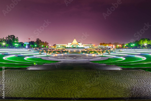 park center area filled with grass in circles and play area with twilight sky background at night