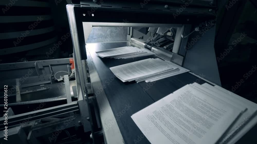 White sheets of paper moving on a typographic conveyor, automated machine. White sheets of paper moving on a typographic conveyor, automated machine.