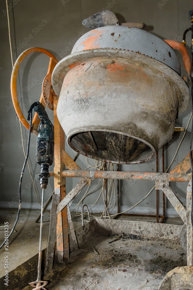 Concrete mixer and hammer drill at the construction site Concrete mixer and hammer drill at the construction site