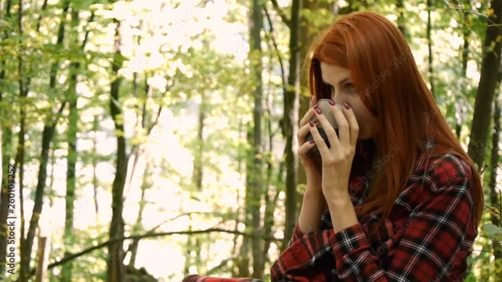Young woman in a park or in the forest drinking coffee or tea from a cup. Young woman in a park or in the forest drinking coffee or tea from a cup.