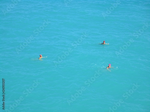 drei Schwimmer mit pinken Badehauben 