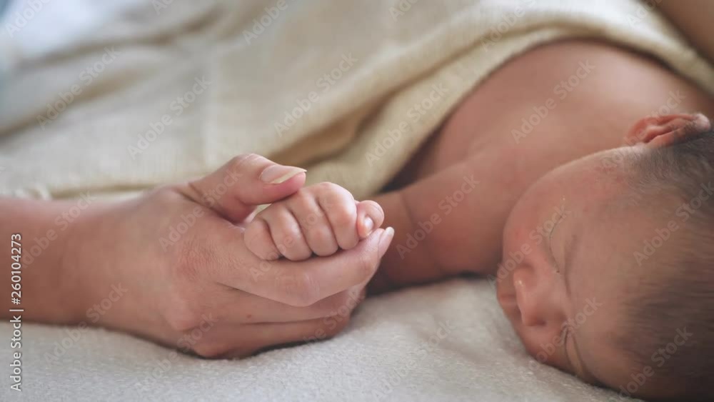 Close up Happy mother holding hand new born Baby girl. care, Healthcare, love, relationship concept Close up Happy mother holding hand new born Baby girl. care, Healthcare, love, relationship concept
