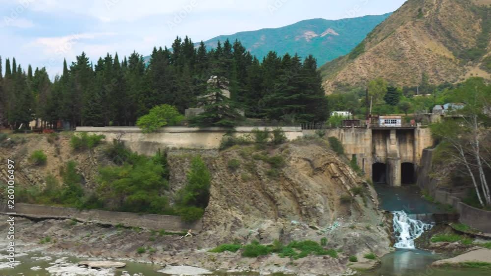 Jvari Monastery, the Temple of the Cross, majestic church in Georgia on top of high mountain above dam for water, view of nature of Asian country, concrete structures of humanity with life of trees