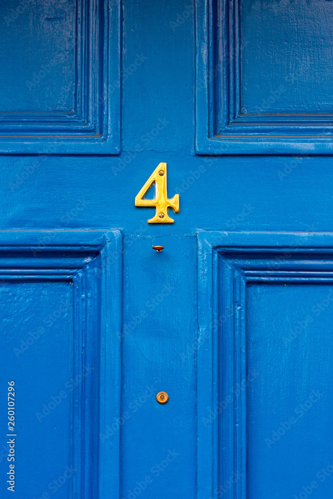 Flirty four in shiny yellow on a blue wooden door Flirty four in shiny yellow on a blue wooden door