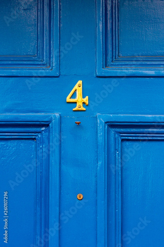 Flirty four in shiny yellow on a blue wooden door