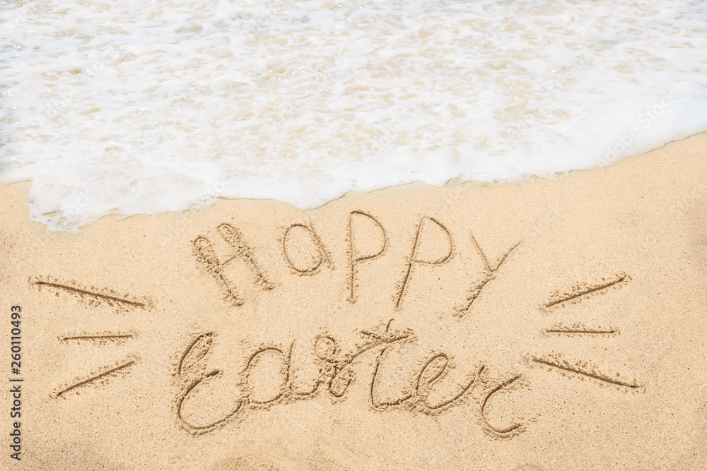 Fototapeta premium Wesołych Świąt Wielkanocnych tło napis z jajkami na piaszczystej plaży