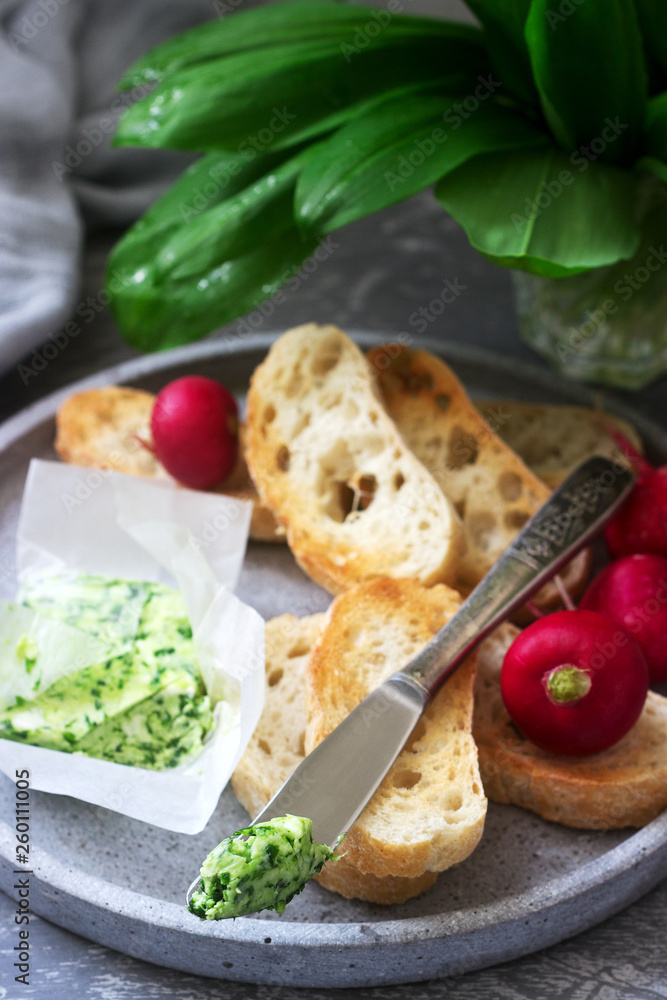 Butter with wild garlic, slices of bread and radish, ingredients for making a sandwich.