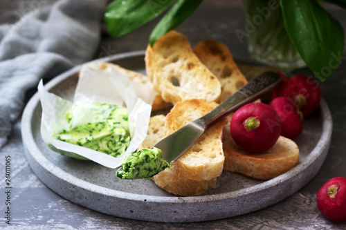 Butter with wild garlic, slices of bread and radish, ingredients for making a sandwich.