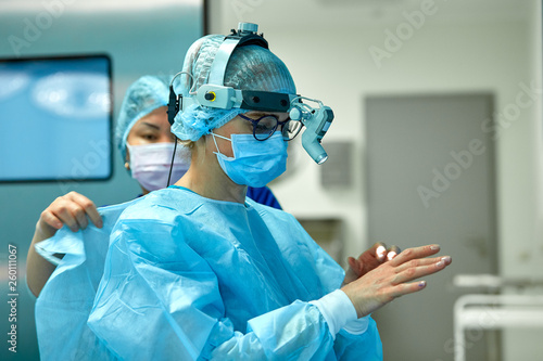 Fotografija Surgeons wear sterile clothing before surgery