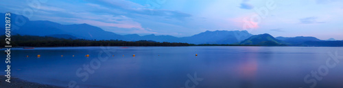 Silence of nature in the early evening - Panoramic view over sea in front of green hills 