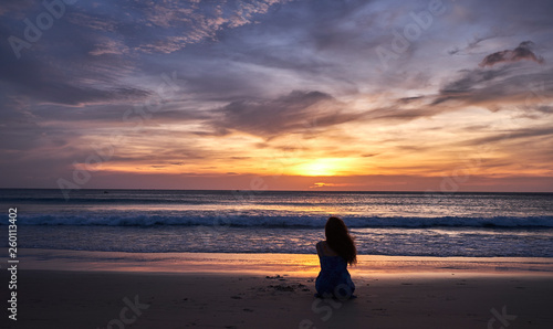 girl sitting at sunset by the sea