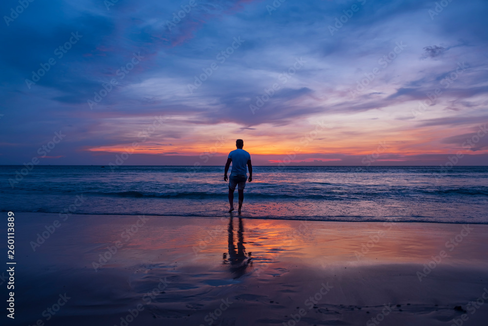 Fototapeta premium Man watching sunset on the beach